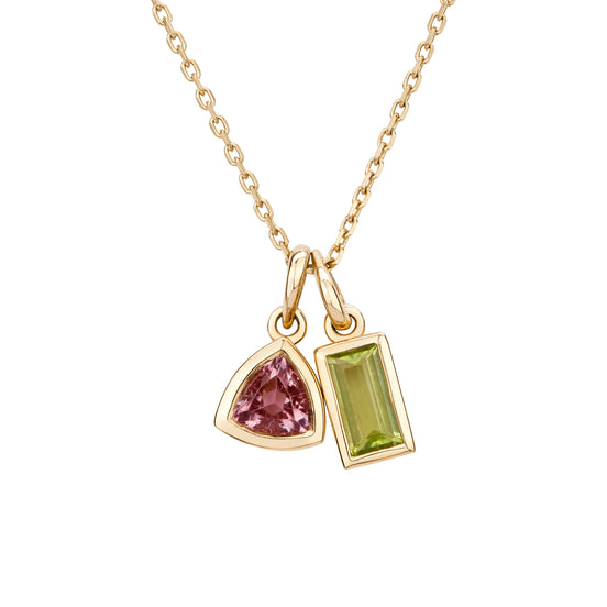 Gold necklace with two gemstone pendants on a white background