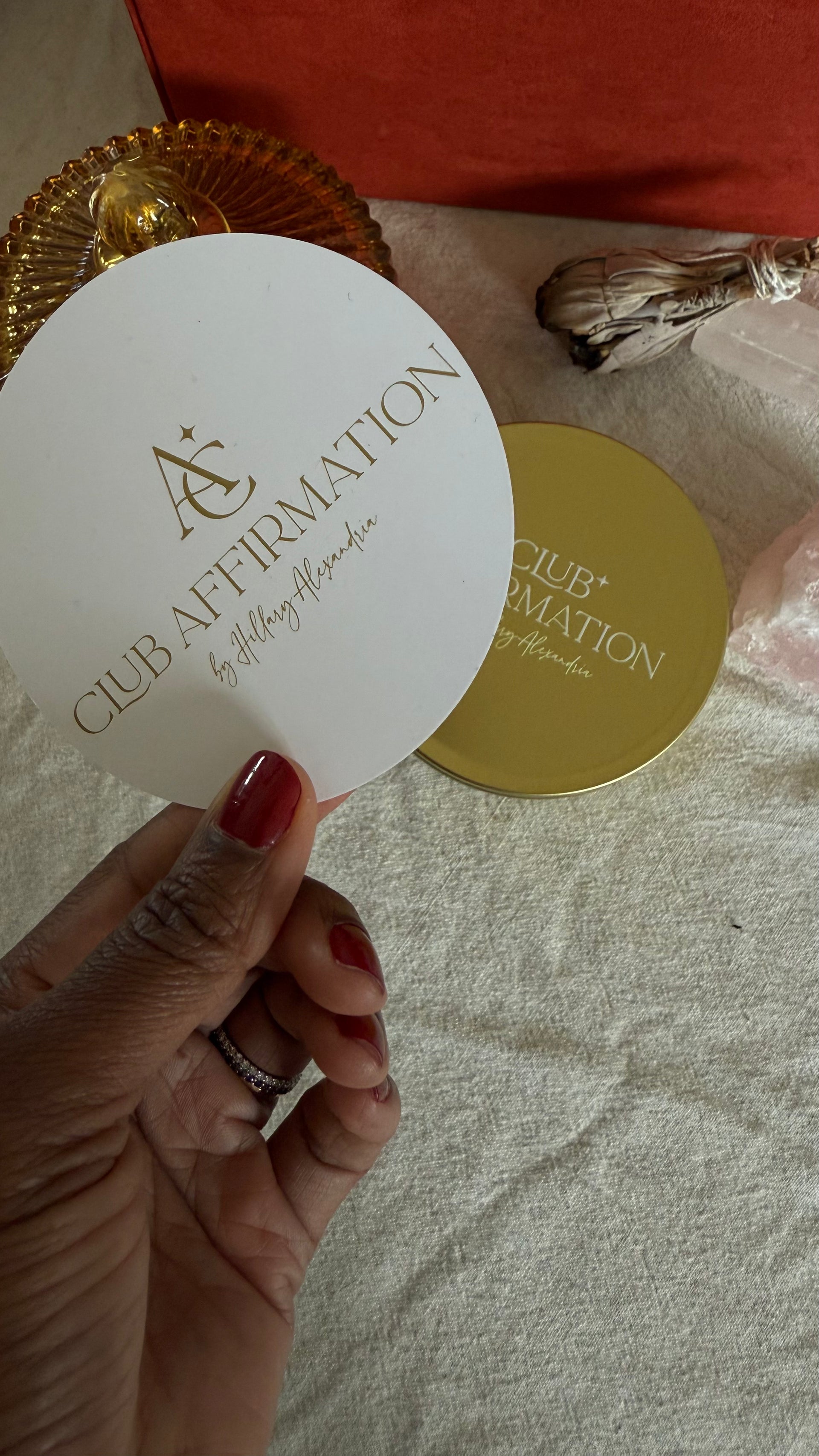Hand holding a white card with 'Club Affirmation' branding on a textured surface.