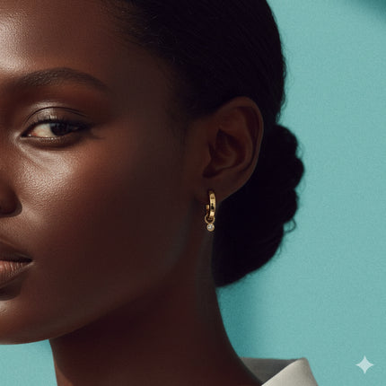 Close-up of a woman wearing gold earrings against a teal background