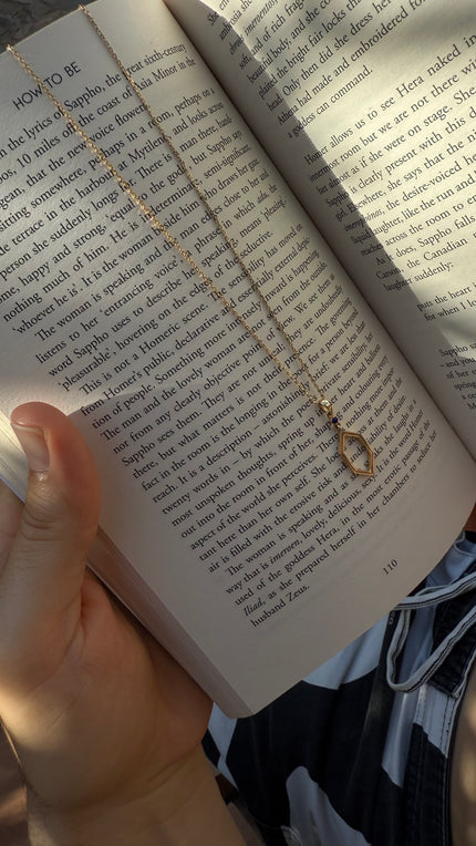 Open book with a necklace held over it