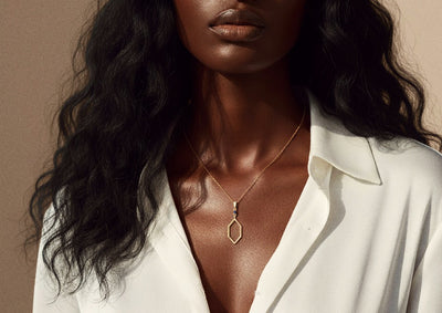 Woman wearing a gold necklace with a plain background